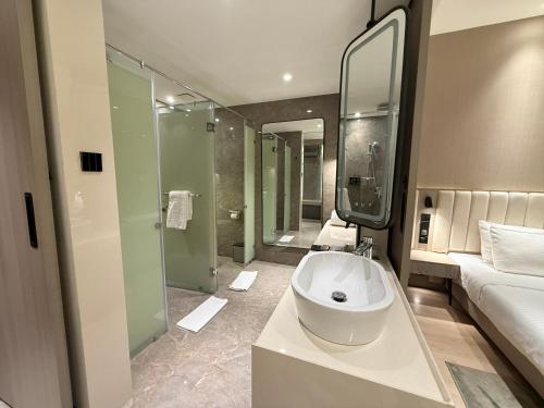 a bathroom with a sink and a large mirror at Vijan Mahal in Jabalpur