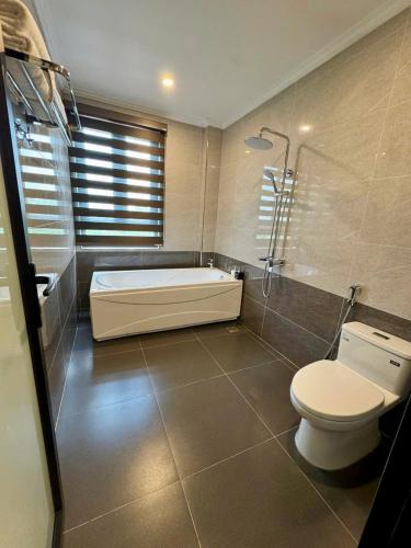 a bathroom with a bath tub and a toilet at Family Transit Hotel in Thach Loi