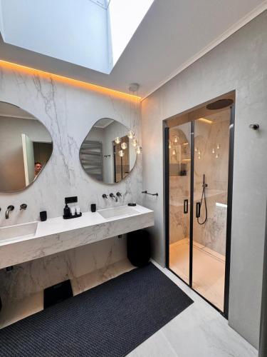 a bathroom with two sinks and a shower at Hotel Bartaccia in Propriano