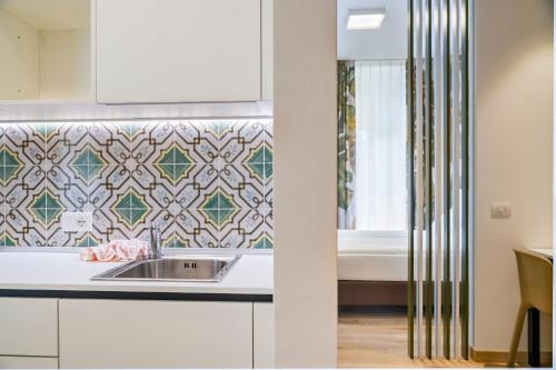a kitchen with a sink and a bed at lillil - Popping Holiday in Riva del Garda
