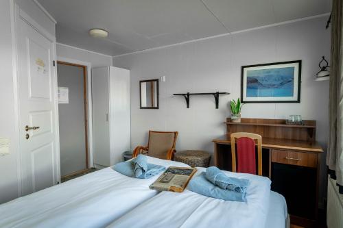 a bedroom with a bed and a desk and a table at Mary-Ann's Polarrigg in Longyearbyen