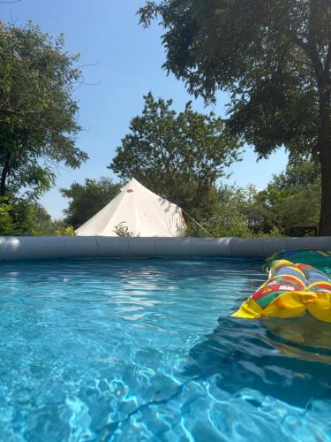 a tent and a swimming pool with a tent at The Ozorian Rooms & Glamping in Ozora