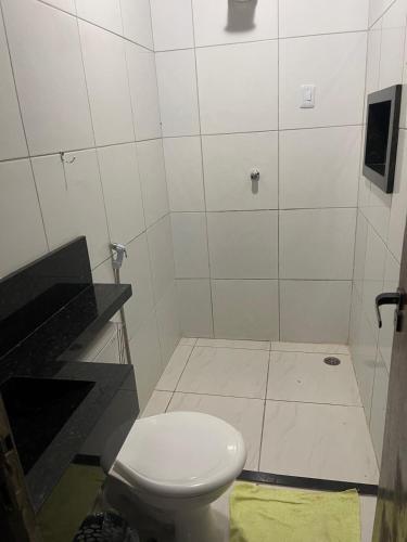 a bathroom with a white toilet in a room at Casa grande in Garanhuns