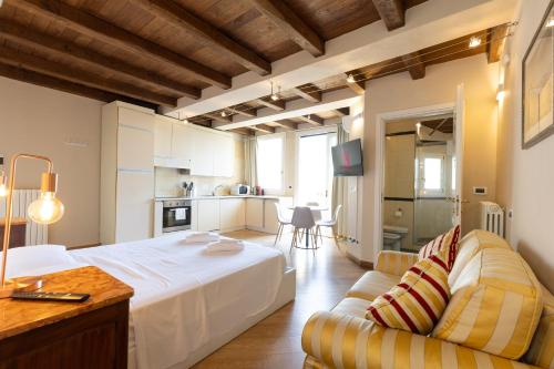 a bedroom with a bed and a couch and a kitchen at BolognaRoomscom - Santo Stefano Apartments in Bologna