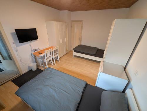 a small room with a bed and a desk at Härtsfeldwohnungen in Neresheim