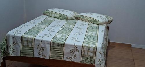 a bed with a blanket and pillows on it at Home Comfort in Poconé