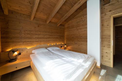 a bedroom with a bed in a wooden wall at Chalet Brisi - Luxury & Bergblick in Wildhaus