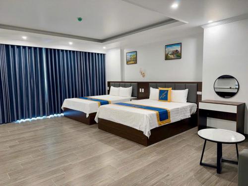 a hotel room with two beds and a table at Family Transit Hotel in Thach Loi