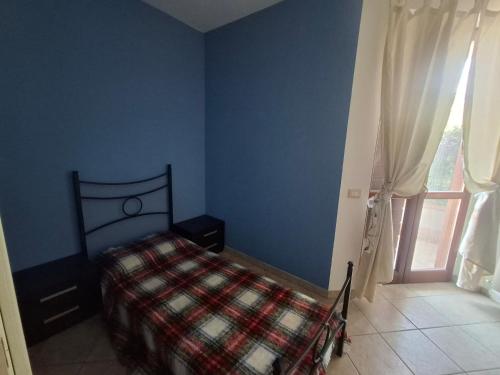 a blue bedroom with a bed and a window at Appartamenti della Marchesa 2 camere in Montichiari