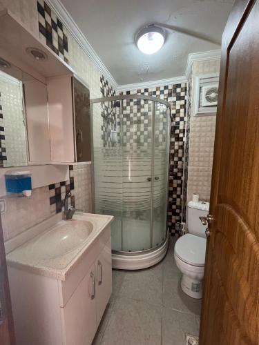 a bathroom with a shower and a toilet and a sink at VAN SERHAT Pansiyon in Ipekyolu