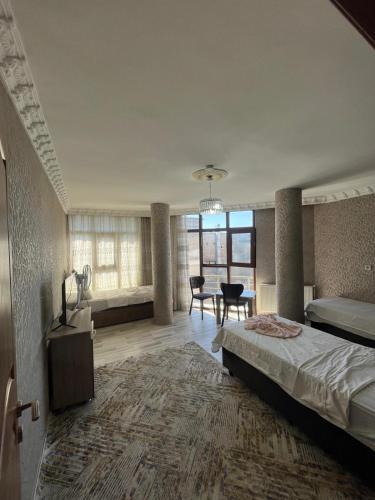 a bedroom with a large bed and a dining room at VAN SERHAT Pansiyon in Ipekyolu