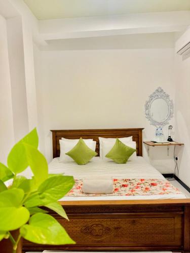 a bedroom with a bed with green pillows at Sea Breeze Guest House Negombo Beach & Airport in Negombo