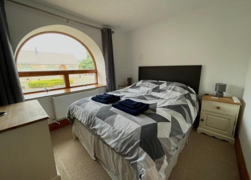 a bedroom with a bed with a large window at The Annexe in Ammanford