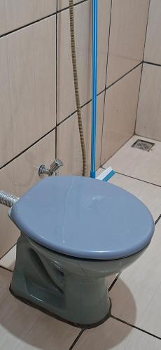 a blue toilet in a bathroom with a shower at Home Comfort in Poconé