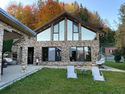a stone house with two chairs and a table at VIP Villa & Spa in Colibiţa
