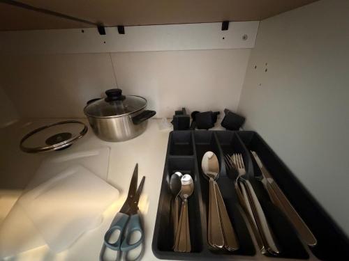 a tray with utensils on a counter with a pot at Apartmán Pardubice 4 in Pardubice