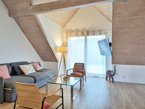 a living room with a couch and a table at L'Hirondelle - Charming flat - in Blotzheim