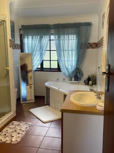 a bathroom with a tub and a sink and a window at 303 Kusweg Tergniet in Tergniet