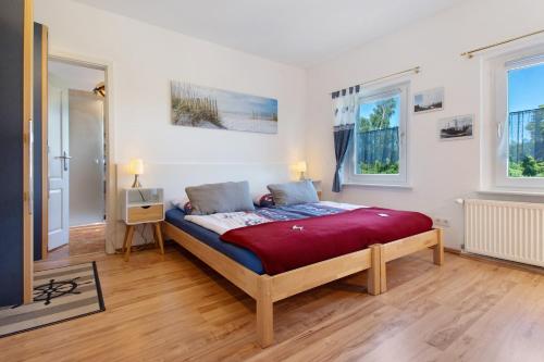 a bedroom with a large bed in a room with windows at Villa Wiese Störtebecker in Katzow