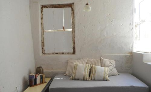 a bed in a room with a mirror and a window at De Waenhuis Cottage in Calitzdorp