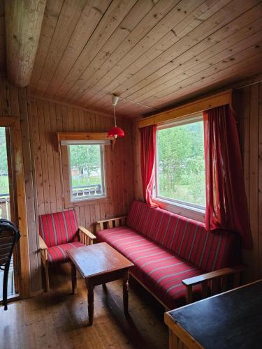 a living room with a red couch and a table at Fossen Camping Fagernes in Døvre