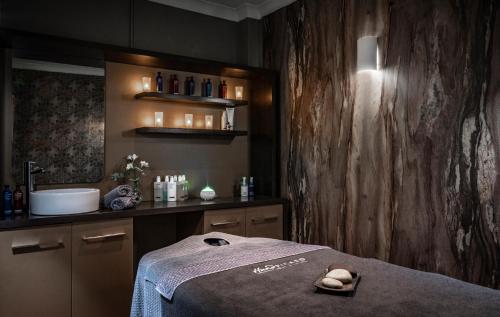 a bathroom with a bed and a sink with a towel at Wood Hall Hotel & Spa in Wetherby