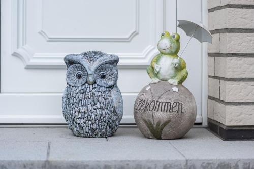 two statues of an owl and a frog on a rock at Ferienwohnung Am Walde 35177 in Hesel
