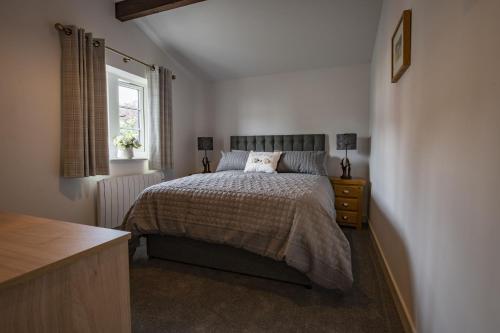 a bedroom with a bed and a window at The Smithy in Kettlewell