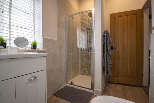 a bathroom with a shower with a toilet and a sink at The Smithy in Kettlewell