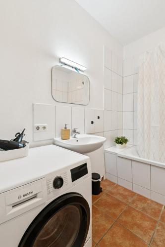a washing machine in a bathroom with a sink at Arbio Monteurzimmer Behnitzer Parking included in Nauen