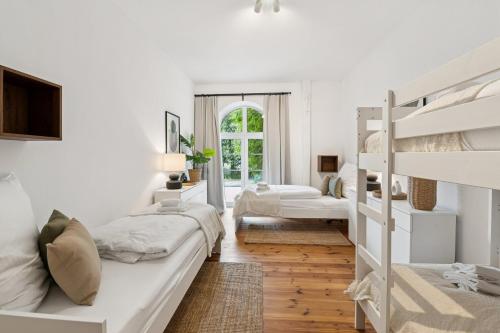 a white bedroom with two bunk beds and a window at Arbio Monteurzimmer Behnitzer Parking included in Nauen