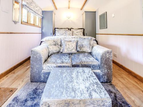 a living room with a couch and a bed at Snow Drop Hut in Alkborough
