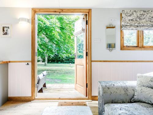 a living room with a door open to a yard at Snow Drop Hut in Alkborough