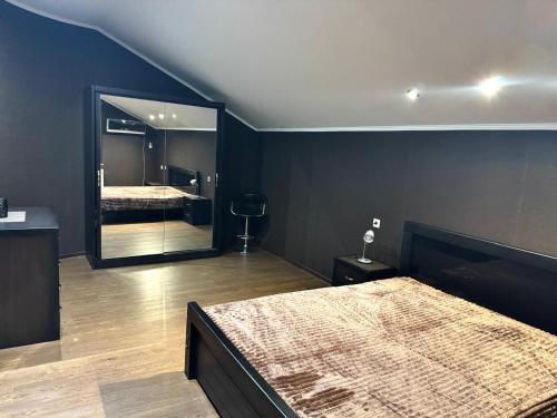 ein Schlafzimmer mit einem Bett und einem großen Spiegel in der Unterkunft Hotel Florencia in Mzcheta