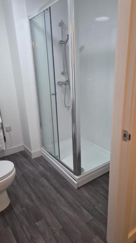 a bathroom with a glass shower with a toilet at Broadway residence G01 in Bradford