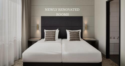 a bedroom with a large white bed with two pillows at Ramada by Wyndham Essen in Essen