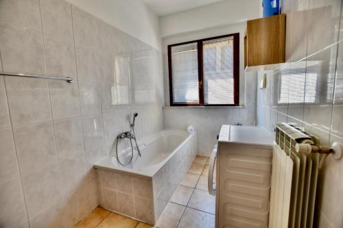 a bathroom with a tub and a sink at 2-Bedroom Airconditioned Lakeview Apartment in Acquaseria