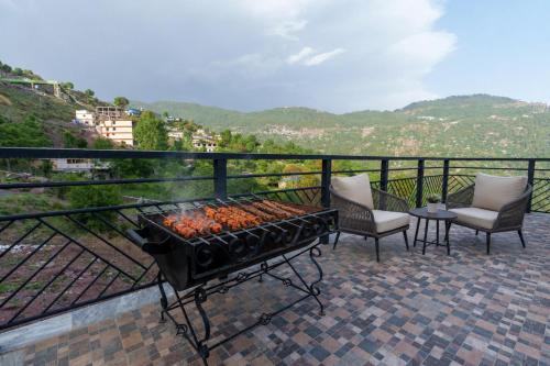 a grill on a balcony with two chairs and a table at 3 BEDROOMS Premium Private Cottage In Murree Mountains in Murree