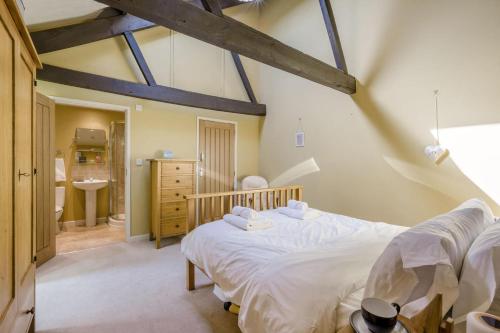 a bedroom with a large bed and a bathroom at 3 Bed in Briningham oc-s44878 in Banningham
