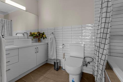 a white bathroom with a toilet and a sink at Tranquility Point in Raymond Island