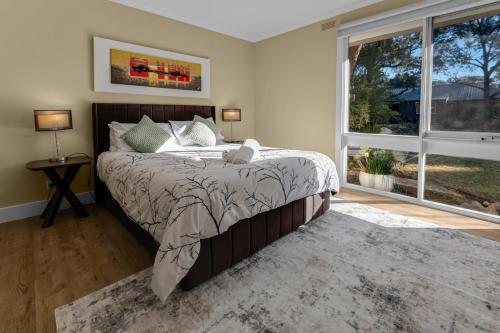a bedroom with a bed and a large window at Koalas Songs in Raymond Island