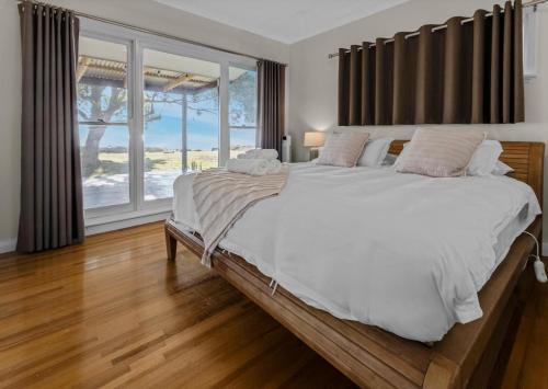 a bedroom with a large bed and a large window at Tranquility Point in Raymond Island