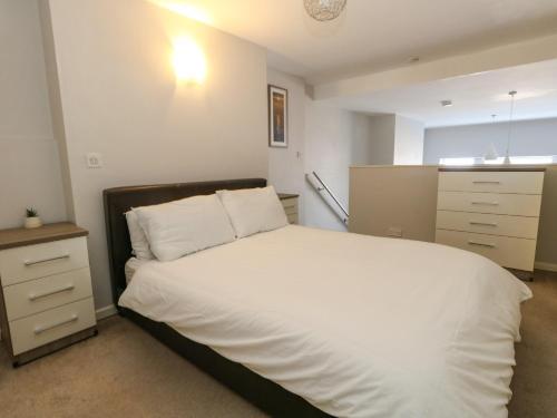 a bedroom with a large white bed with a night stand at Chandlers Nook in Portland