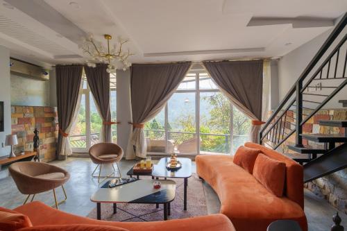 a living room with an orange couch and chairs at 3 BEDROOMS Premium Private Cottage In Murree Mountains in Murree