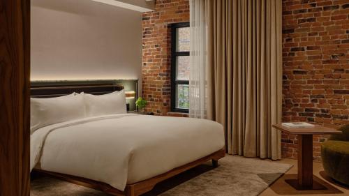 a bedroom with a large bed and a brick wall at Hotel Nelligan in Montreal