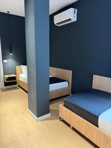 a bedroom with two beds and a blue wall at NOOR Boutique Hotel in Koplik