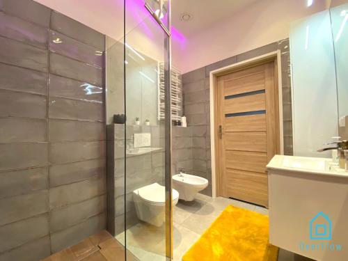 a bathroom with a toilet and a glass shower at NaWypasie Apartment with Sauna Beautiful Garden SUP Board and Just 30 Minutes from Gdańsk and Gdynia in Szemud
