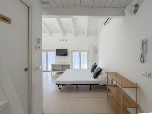 a white room with a bed and a television at Roma 17 in Cassina deʼ Pecchi