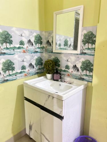 a bathroom with a white sink and a mirror at JAJABAR Homestay in Dum Duma