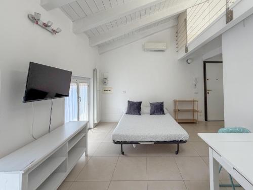 a white room with a bed and a flat screen tv at Roma 17 in Cassina deʼ Pecchi